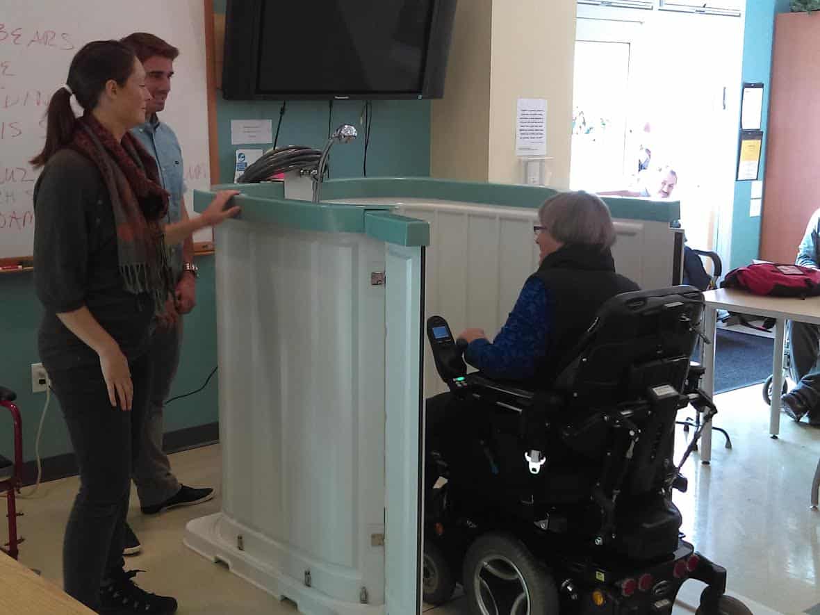 Woman entering in a shower bay on a wheelchair