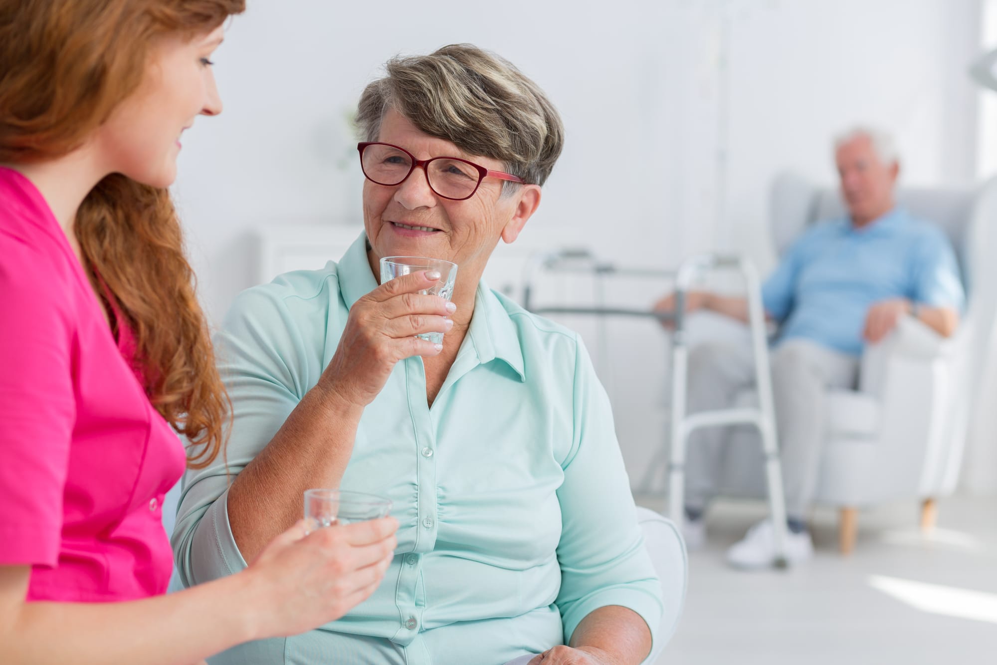 Nurse with elderly woman drinking water