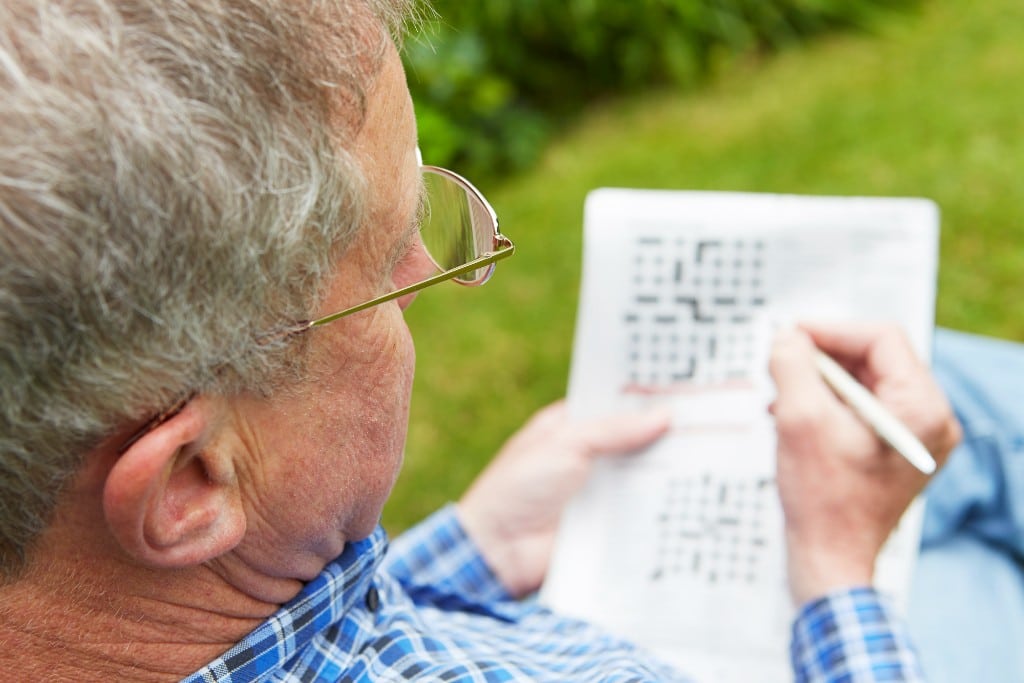 Senior man doing crossword puzzle